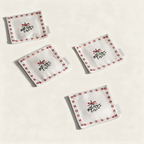 Set of four cotton mistletoe drink napkins with red bows, on a cream background