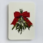 Card with mistletoe and red bow on a light gray background