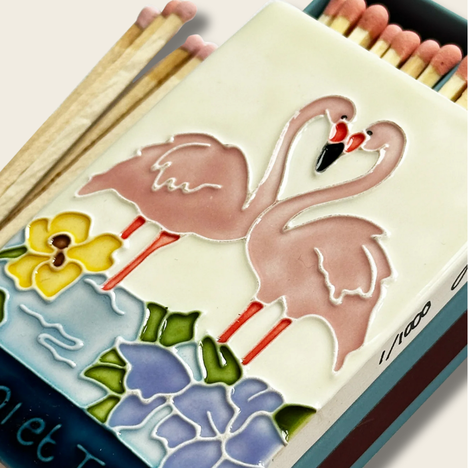 Matchbox with flamingo design and floral elements on a white background