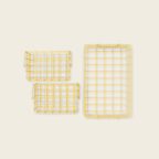 Three yellow wire baskets of different sizes on a beige background