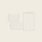 Three white wire baskets of different sizes on a beige background