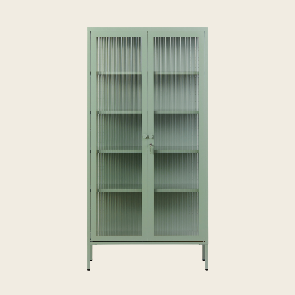 Green metal cabinet with glass doors on a beige background