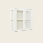 White cabinet with glass doors on a light beige background