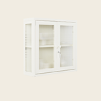 White cabinet with glass doors on a light beige background