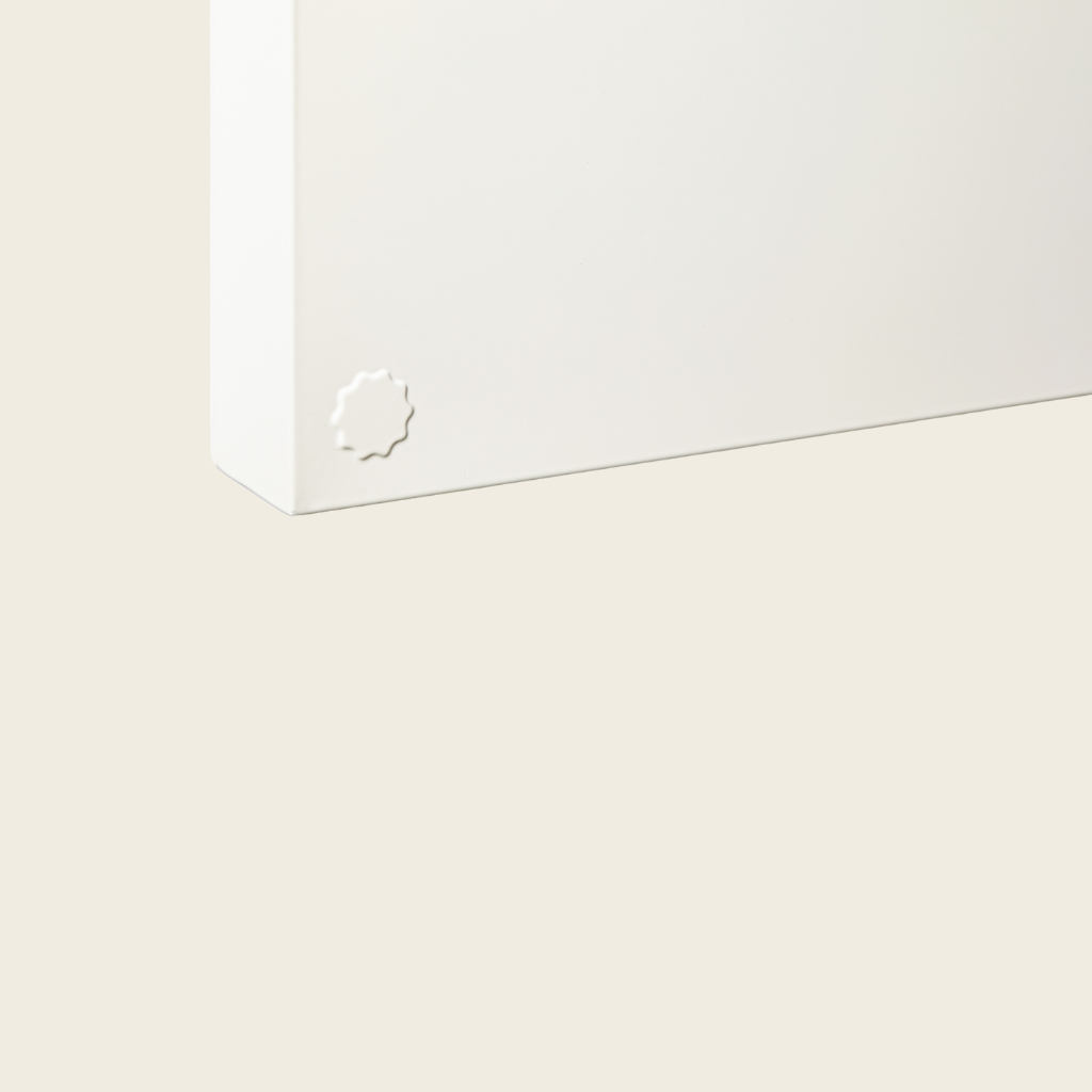 White rectangular box with a brand logo on a light beige background