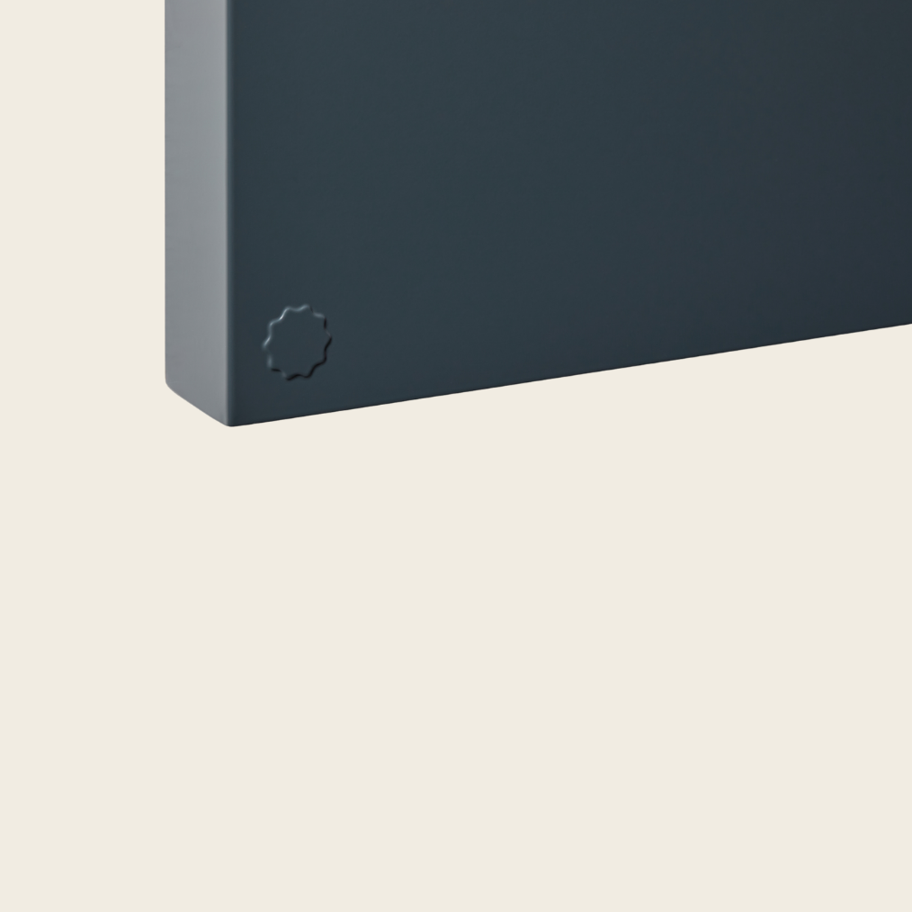 Dark gray rectangular object with a circular design on a beige background