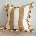 Striped pillow with brown and white colors on a wooden surface.