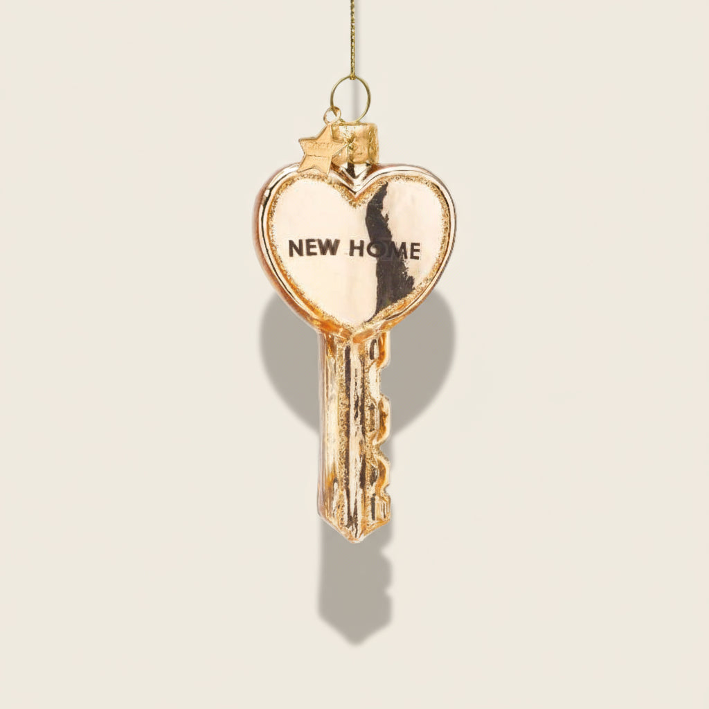Heart-shaped key ornament with 'NEW HOME' text on a white background