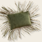 olive cushion with fringe being thrown