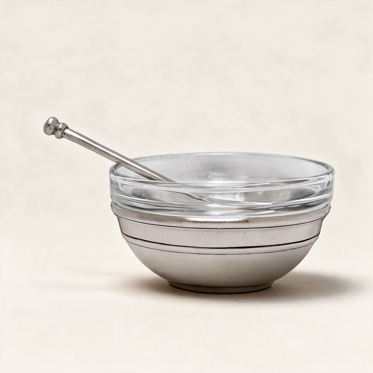 Osteria pewter single condiment holder with glass insert and spoon on a warm cream background