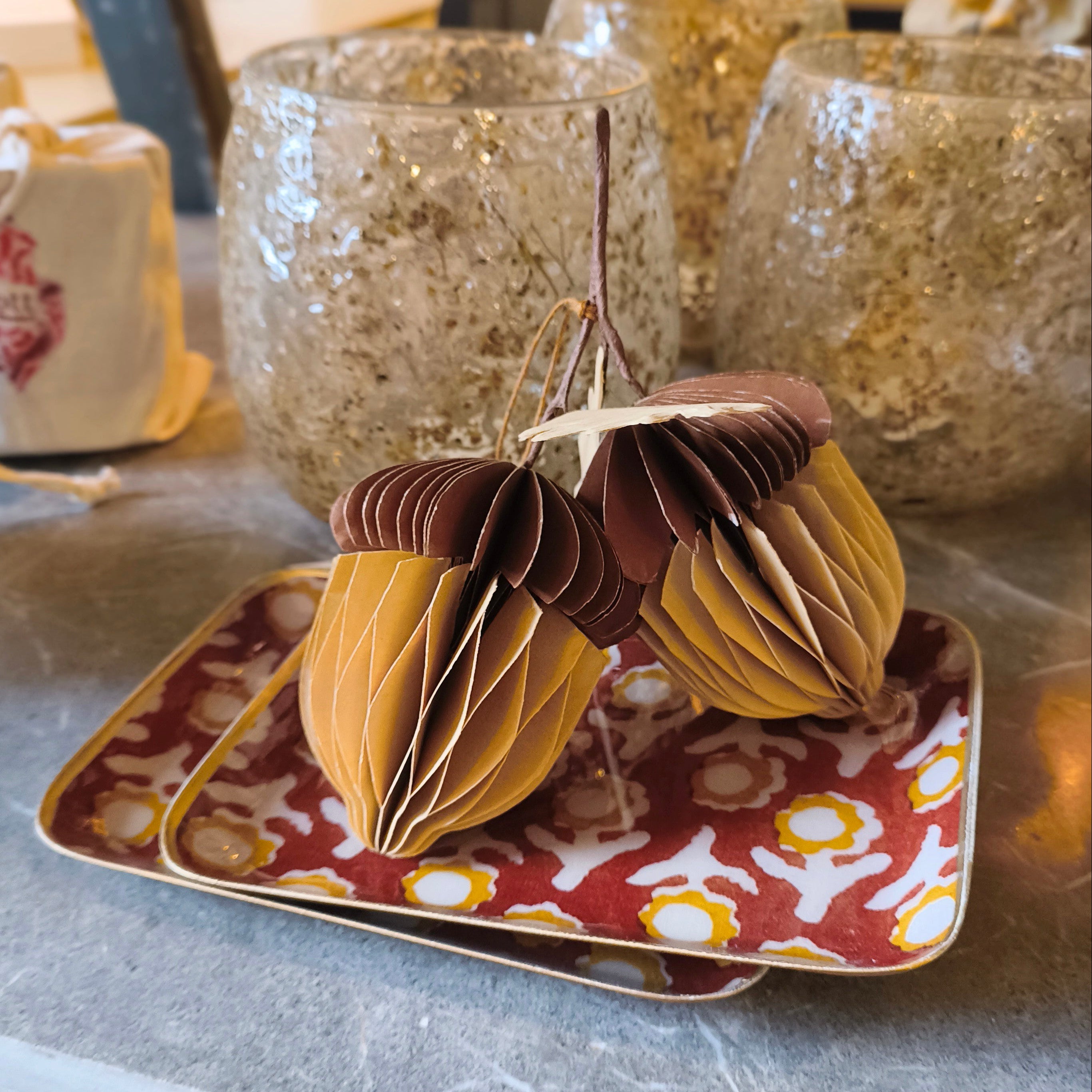 papewr acorn decoration sat on a patterned metal tray