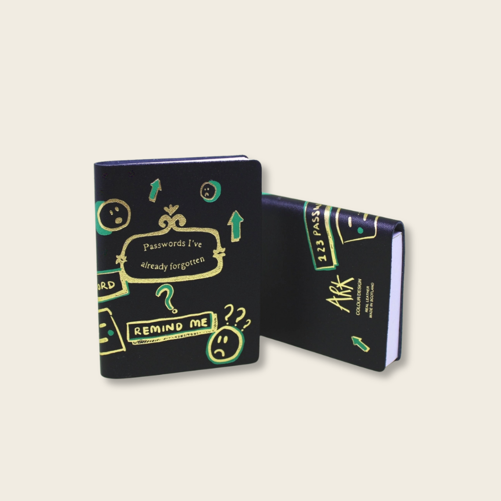 Black notebook with colorful text and graphics on a beige background