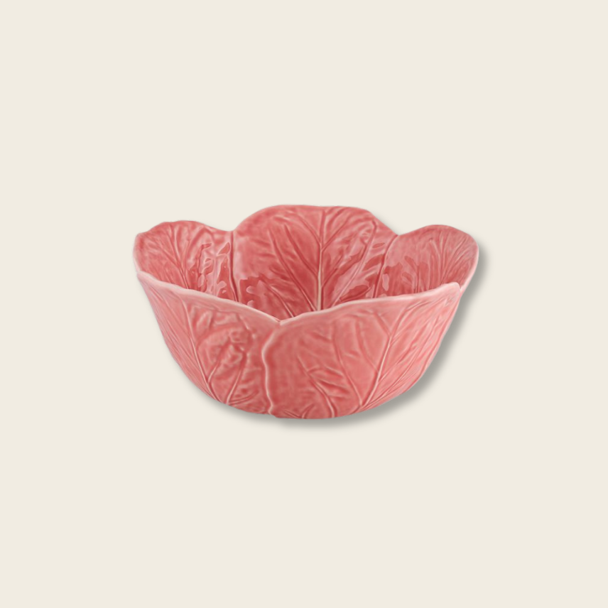 Pink ceramic bowl with leaf design on a beige background