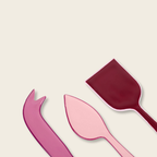 Pink and red plastic cutlery set on a beige background