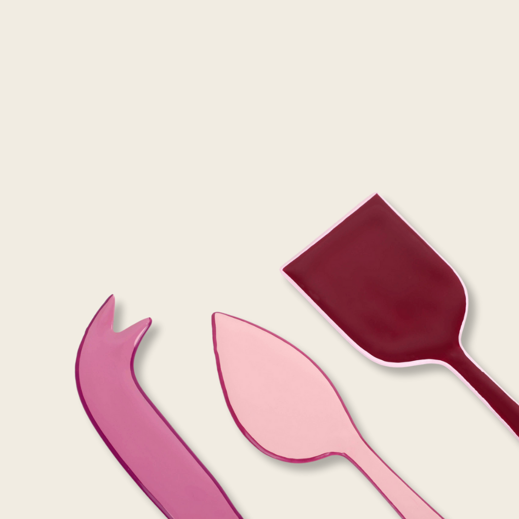 Pink and red plastic cutlery set on a beige background
