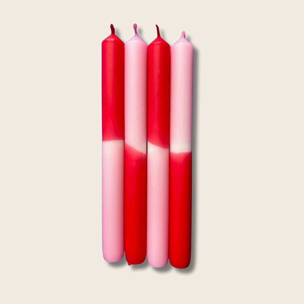 Four red and pink gradient candles on a beige background