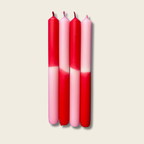 Four red and pink gradient candles on a beige background