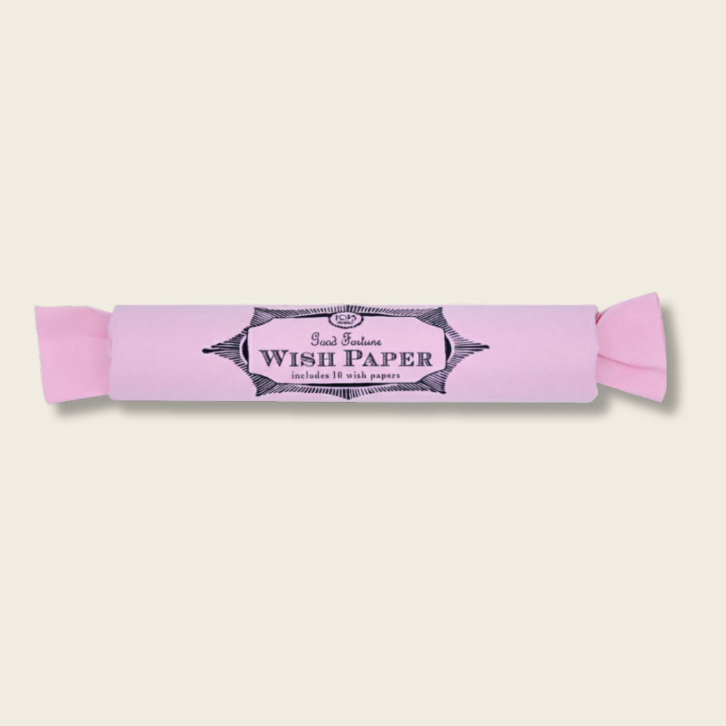 roll of pink wish paper on a beige back ground