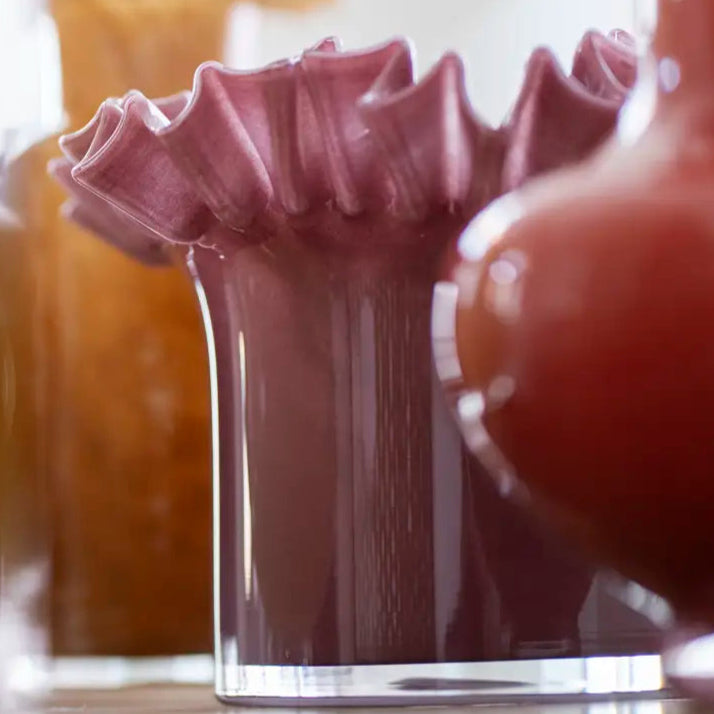Close-up of a decorative glass vase with a textured top on a blurred background