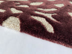 Close up of the Pluma mulberry rug showing the cut and loop pile and scattered motifs