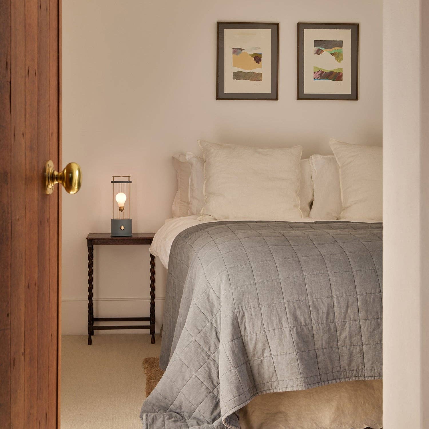 Bedroom with a bed, nightstand, and wall art.