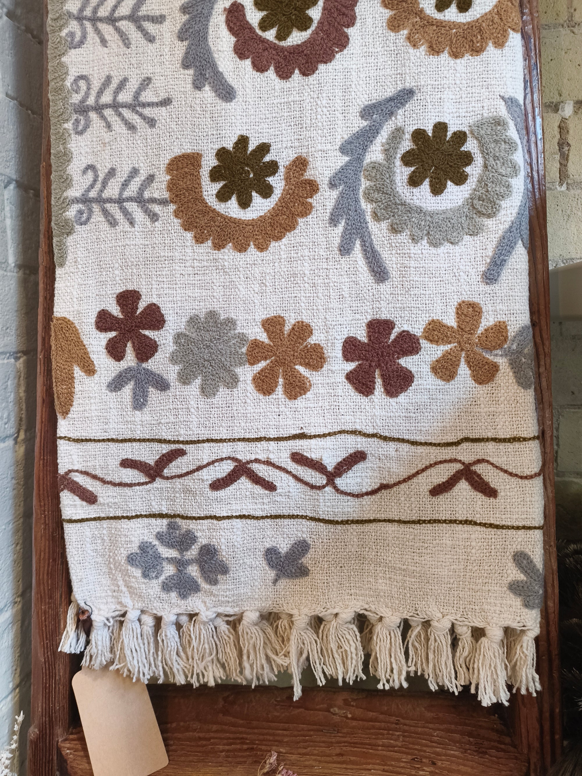 Video of an embroidered throw displayed on wooden ladder