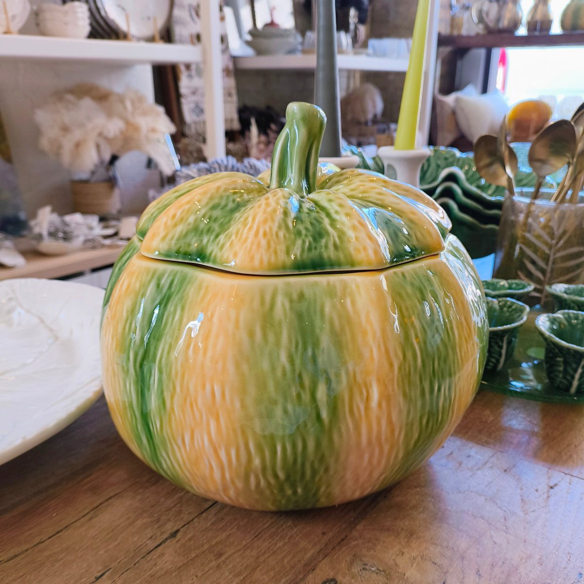 Bordallo Pinheiro pumpkin-shaped lidded tureen with the lid on, on a wooden surface