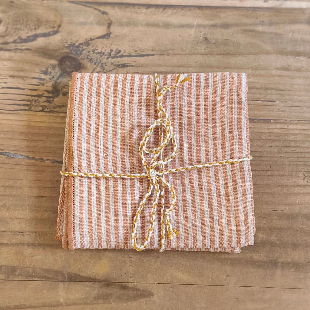Packaged fabric napkin with striped string on a wooden surface