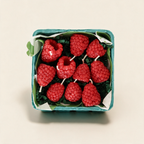 Set of ten raspberry-shaped beeswax candles in a berry basket on a cream background