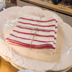 White ceramic plate with a red and white striped cloth on a wooden surface