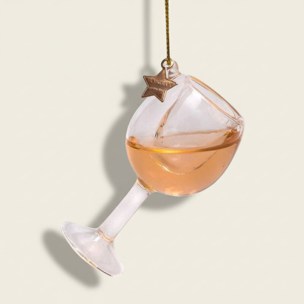 Decorative glass wine glass ornament with a star-shaped tag on a white background