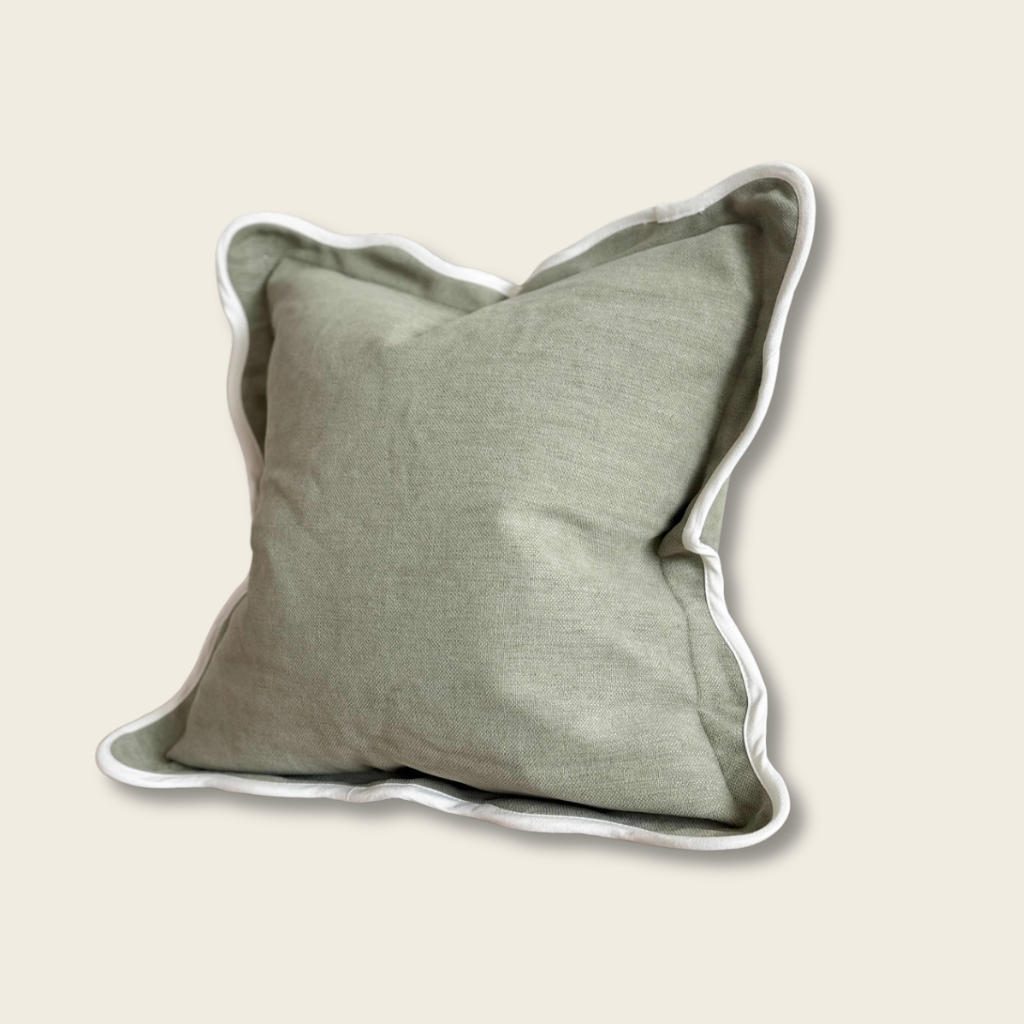 olive green cushion with cream edging on a beige background