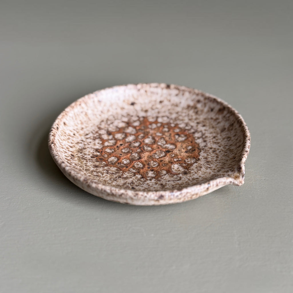 Speckled ceramic dish on a gray background