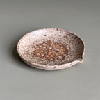 Speckled ceramic dish on a gray background