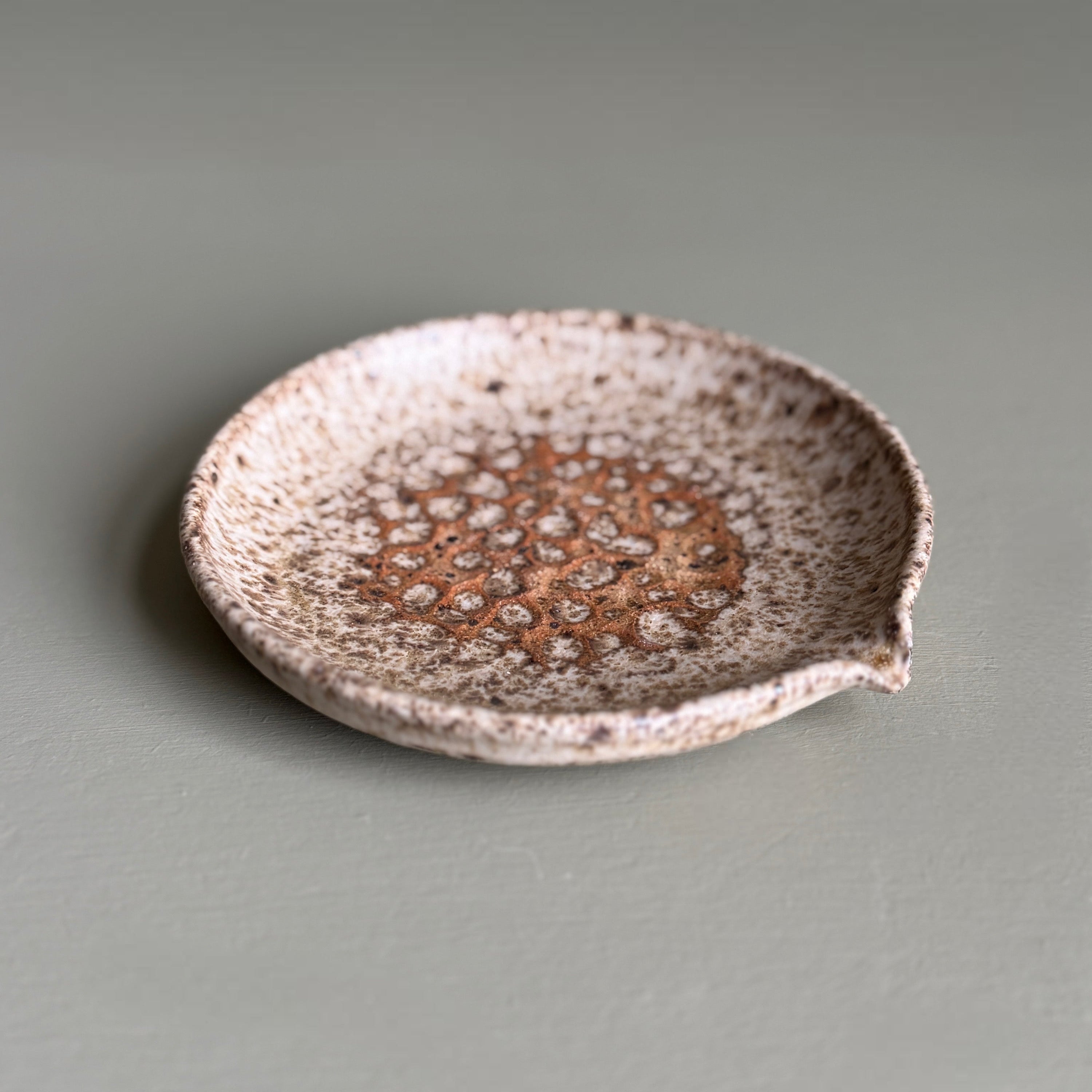 Speckled ceramic dish on a gray background