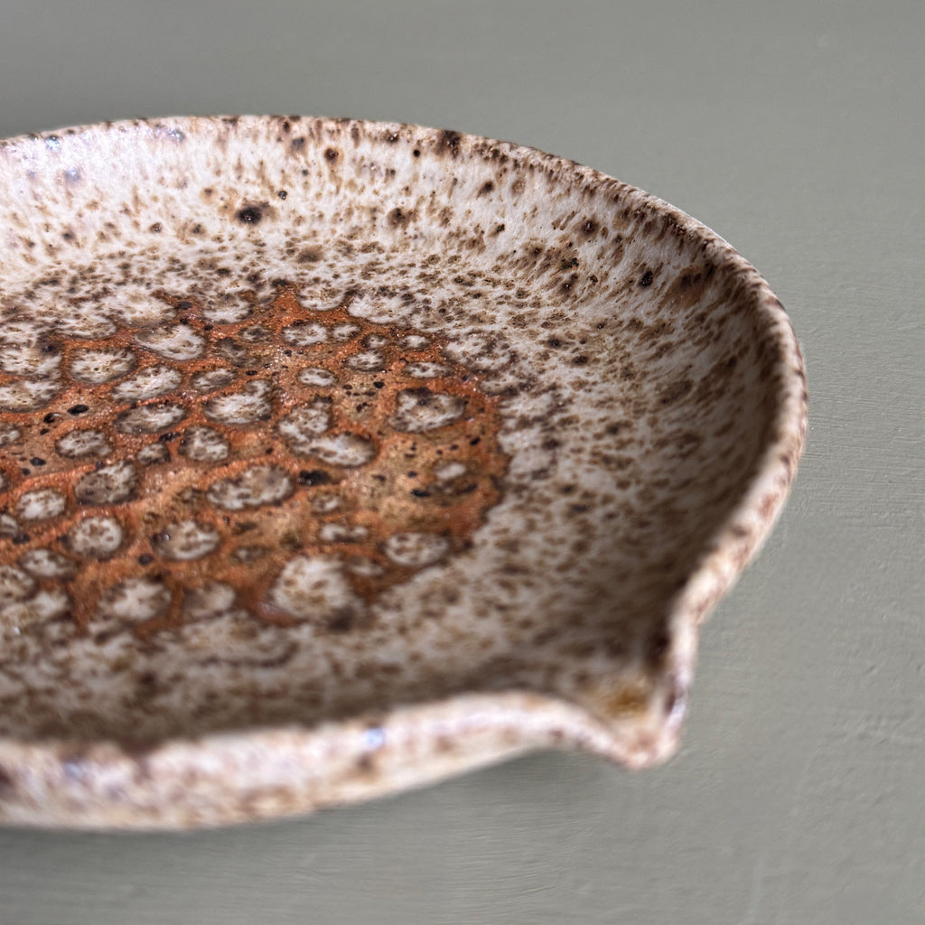 Speckled ceramic bowl on a plain background