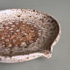 Speckled ceramic bowl on a plain background