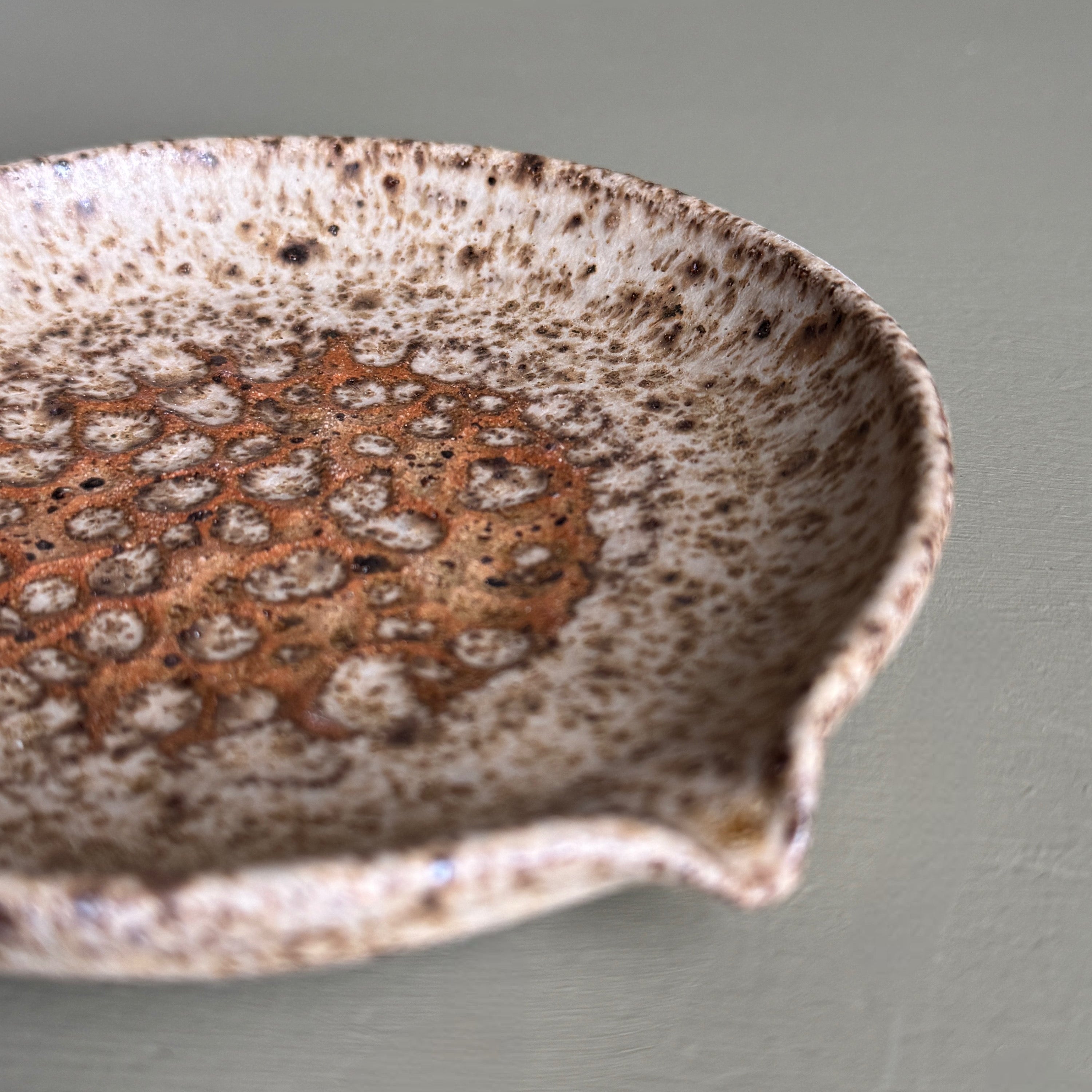 Speckled ceramic bowl on a plain background