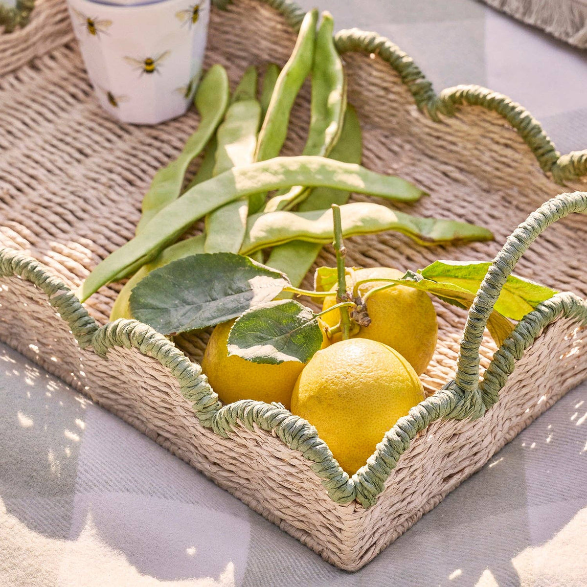 Close-up of the scalloped green painted edge of the woven tray