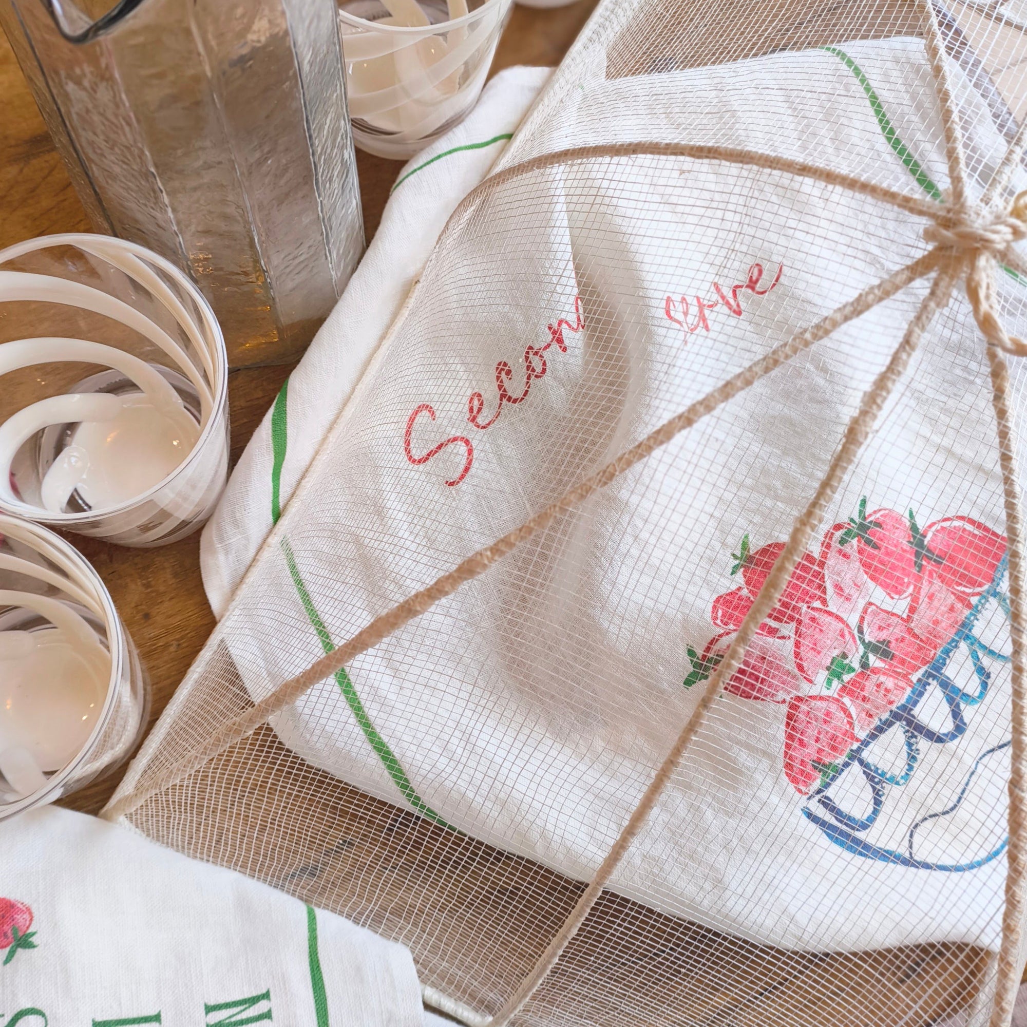 food cover with a strawberry tea towel underneath