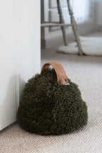 Olive cropped sheepskin door stop with a leather handle