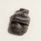 Brown teddy sheepskin hot water bottle cover, on a cream background