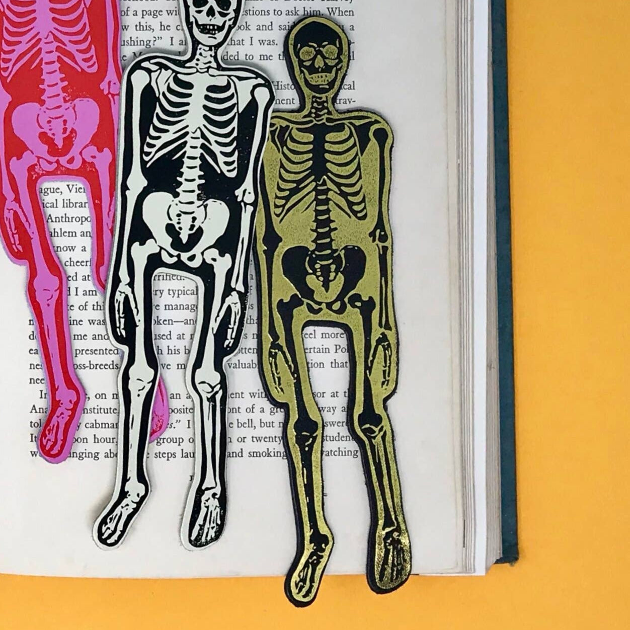 gold foil skeleton black leather bookmark resting on a book