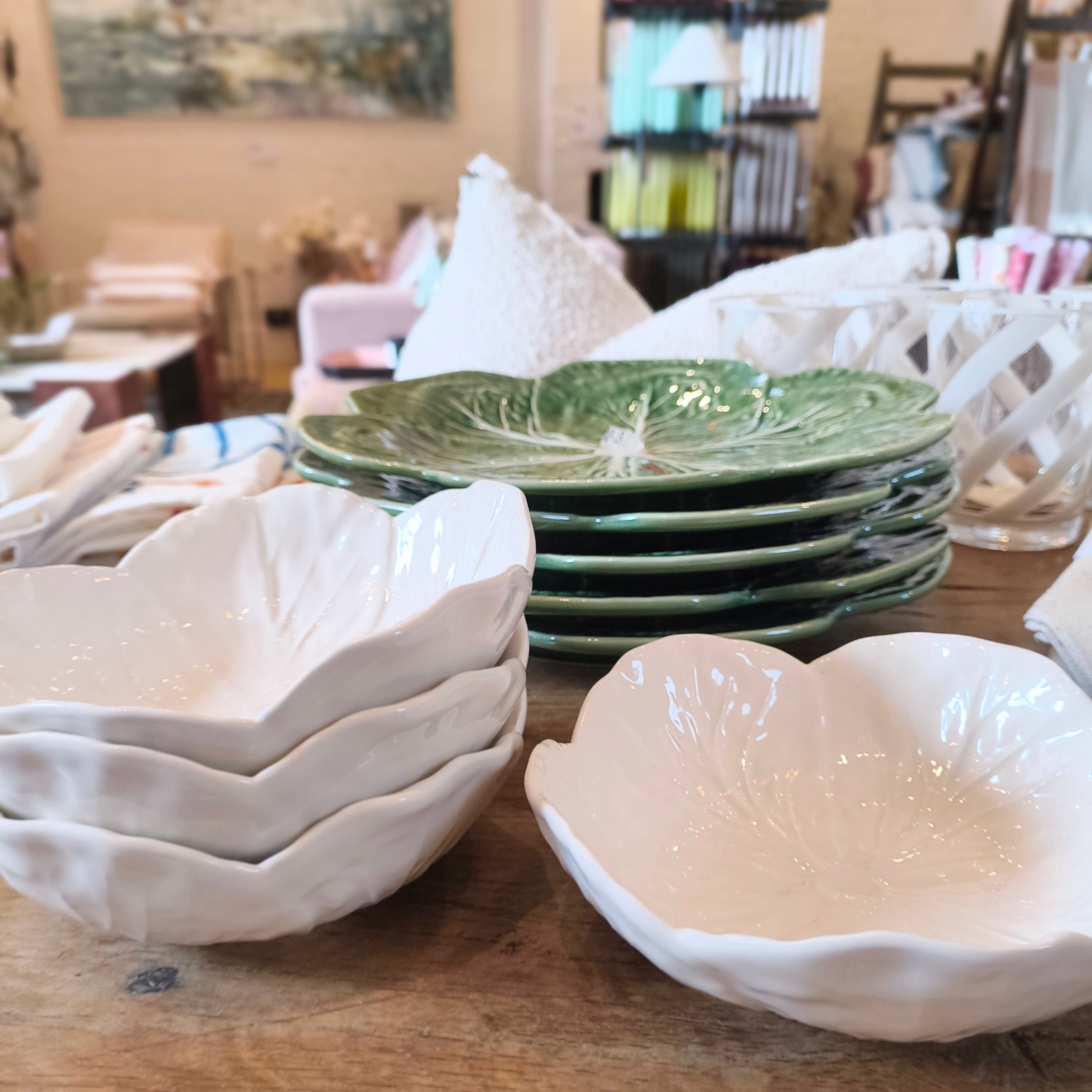 Stacked ceramic bowls and plates on a wooden surface with a blurred background
