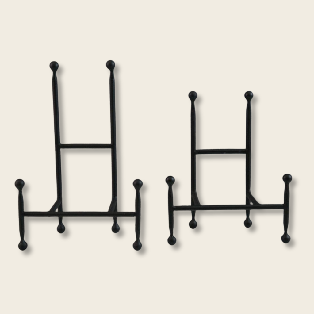 a small and large iron chair style easel on a beige background