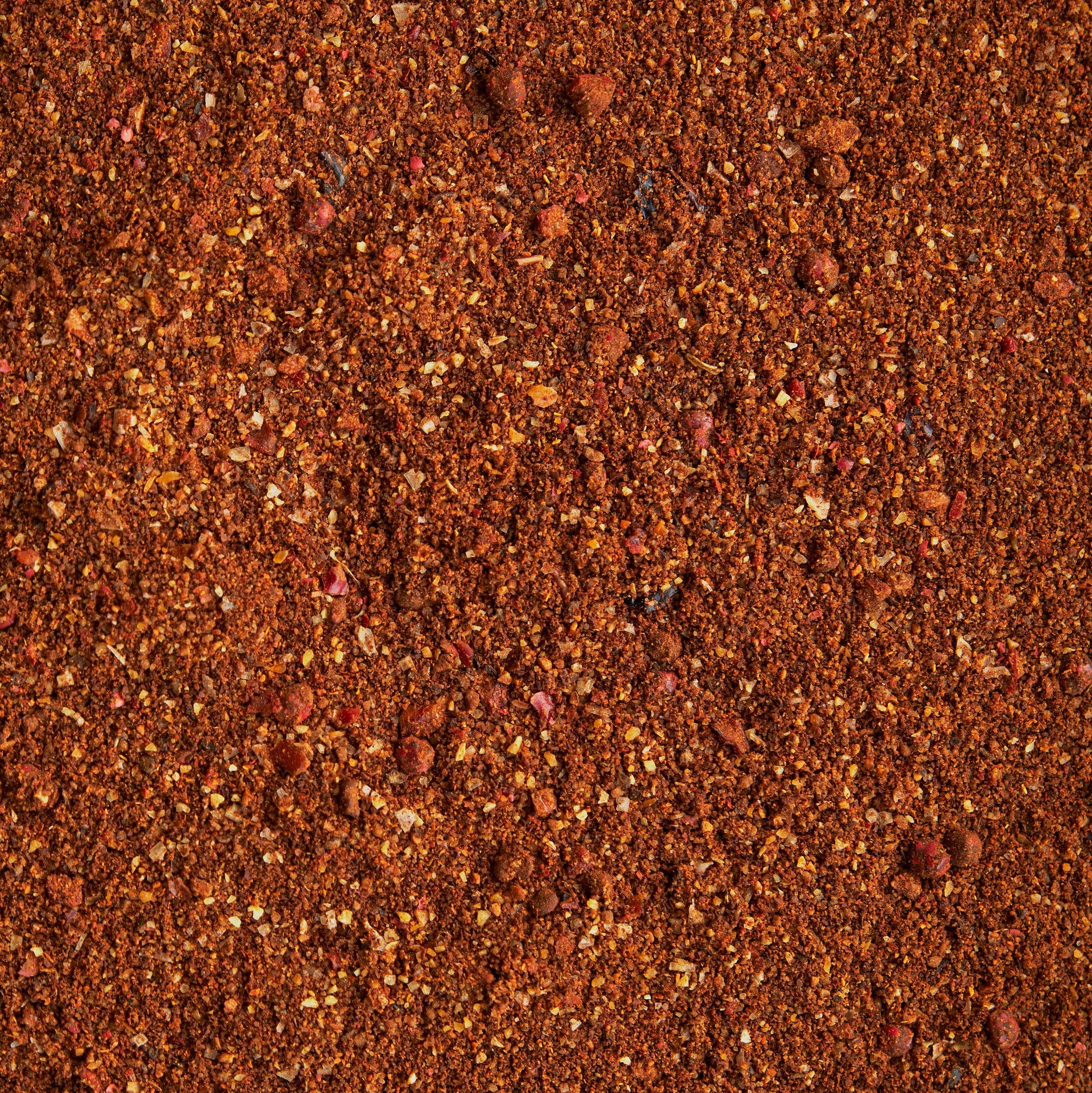 Close-up of red sand or gravel with a textured surface