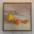Framed painting of lemons and oranges on a neutral background