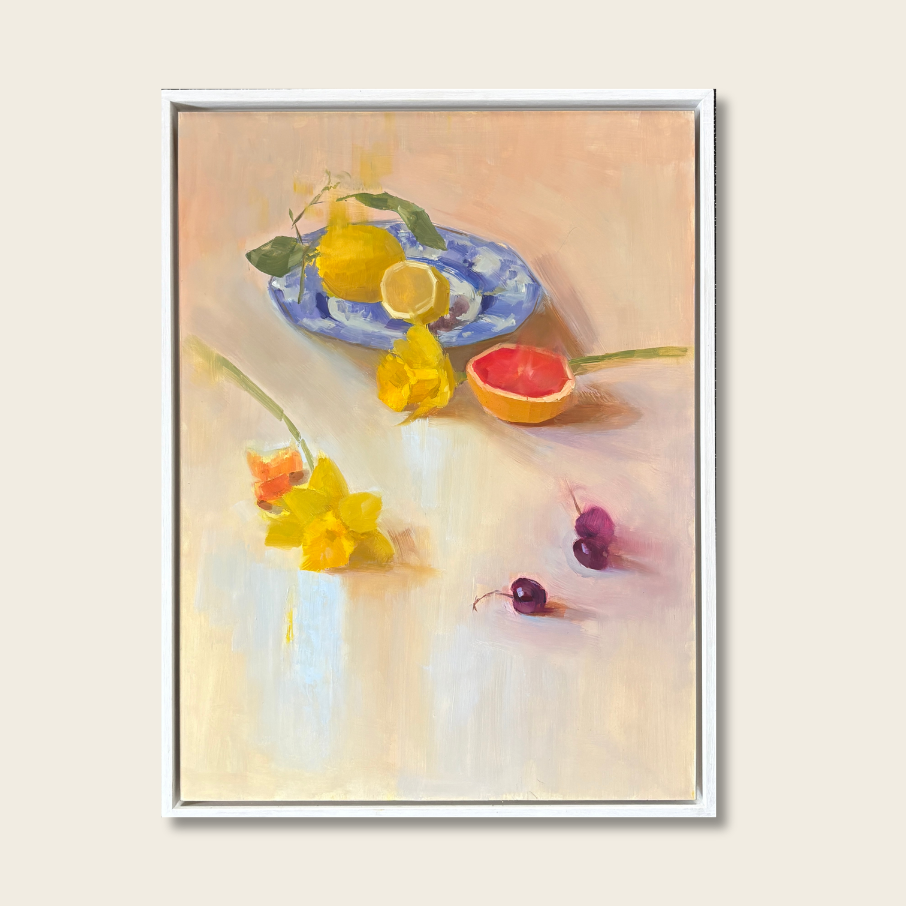 Framed artwork of a still life with lemons, flowers, and fruit on a light background