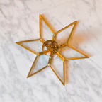 Gold geometric star-shaped object on a marble surface