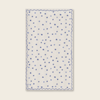White fabric table cloth with blue star pattern on a beige background